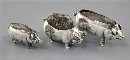 Two Adie & Lovekin novelty silver pin cushions modelled as pigs, Birmingham 1905 and 1906 and a Levi & Salaman pig pen wipe.
